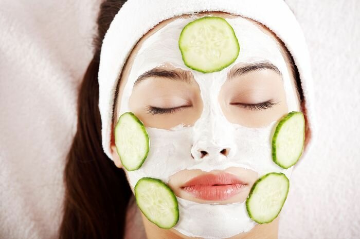 Young woman with cucumber slices on the face in a spa saloon